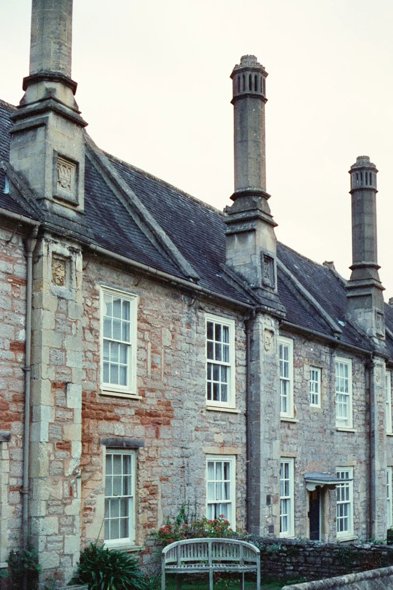 Older stone house with a slate roof and sash windows